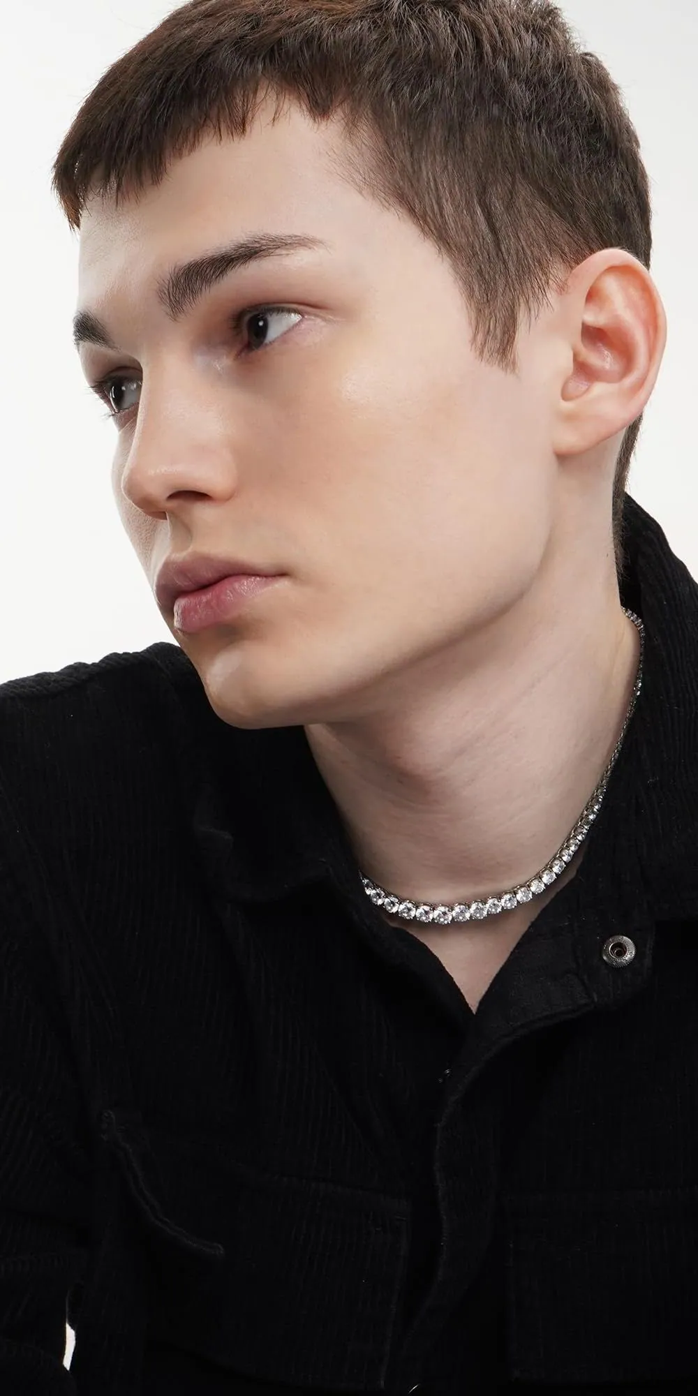 A young man in a black shirt looking to the side