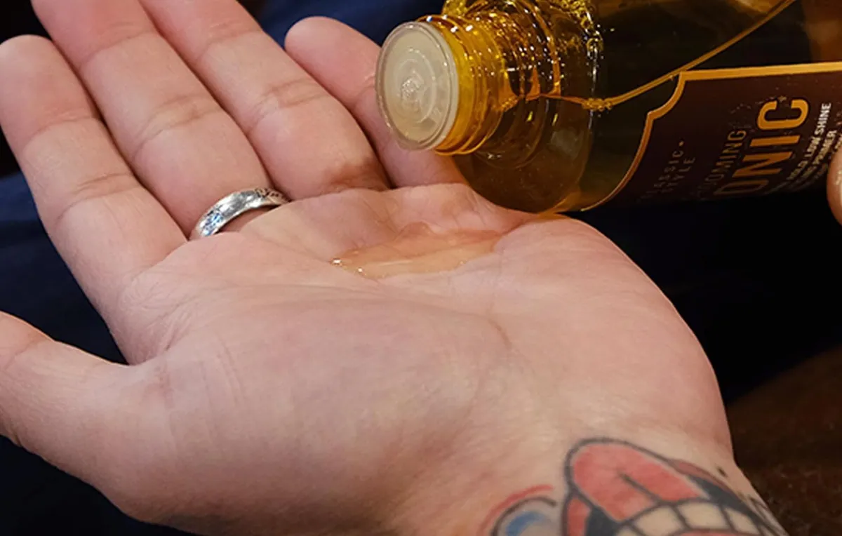 DASHU Classic Grooming Hair Tonic poured into an open palm